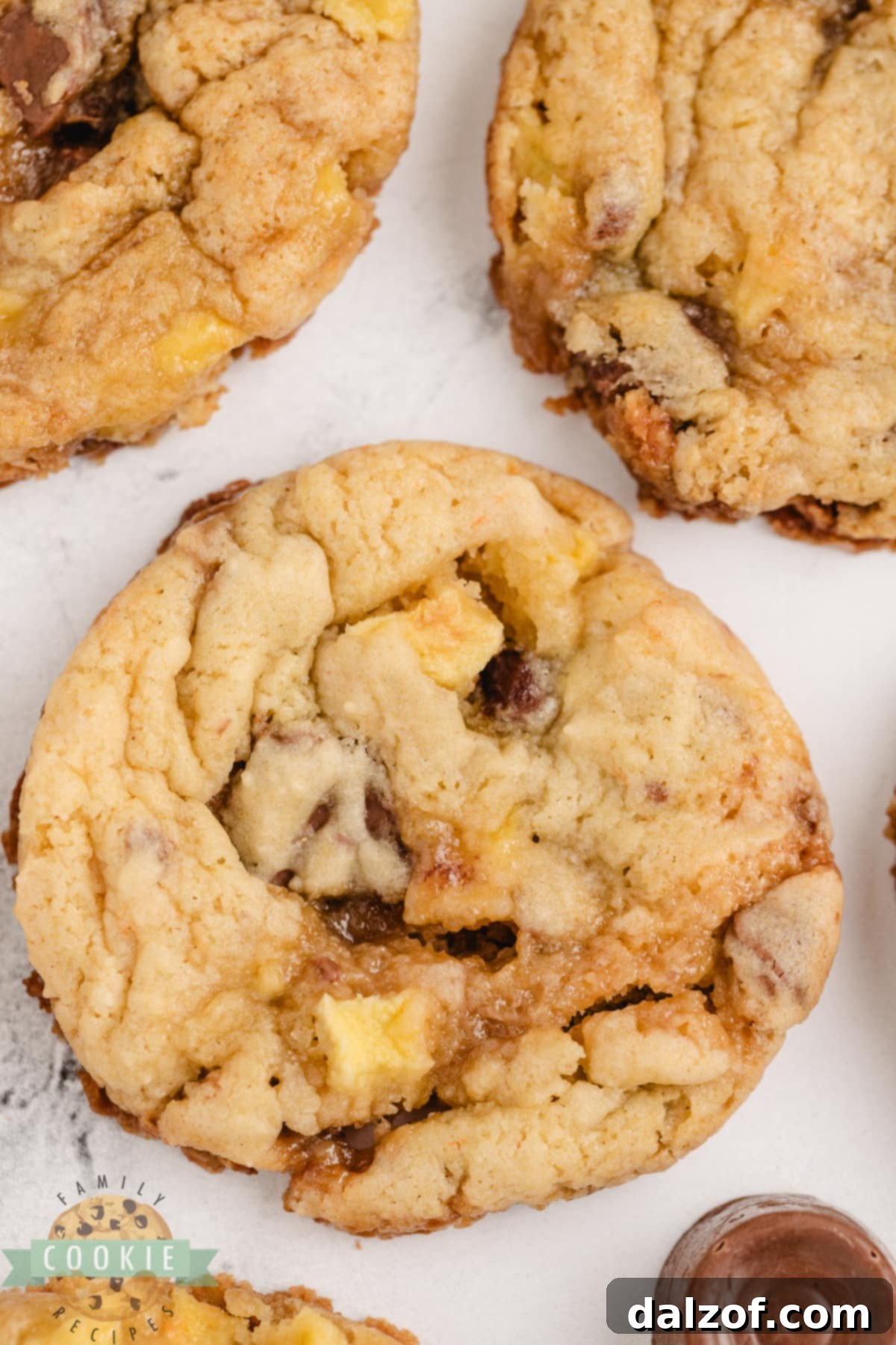 Close-up of baked Caramel Apple Cake Mix Cookies, featuring the golden edges and visible apple and Rolo pieces.