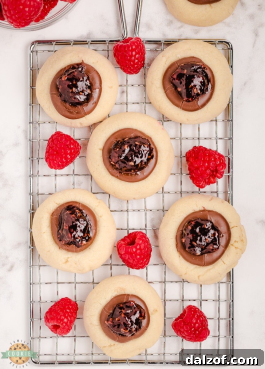 raspberry thumbprint cookies on a cooling rack