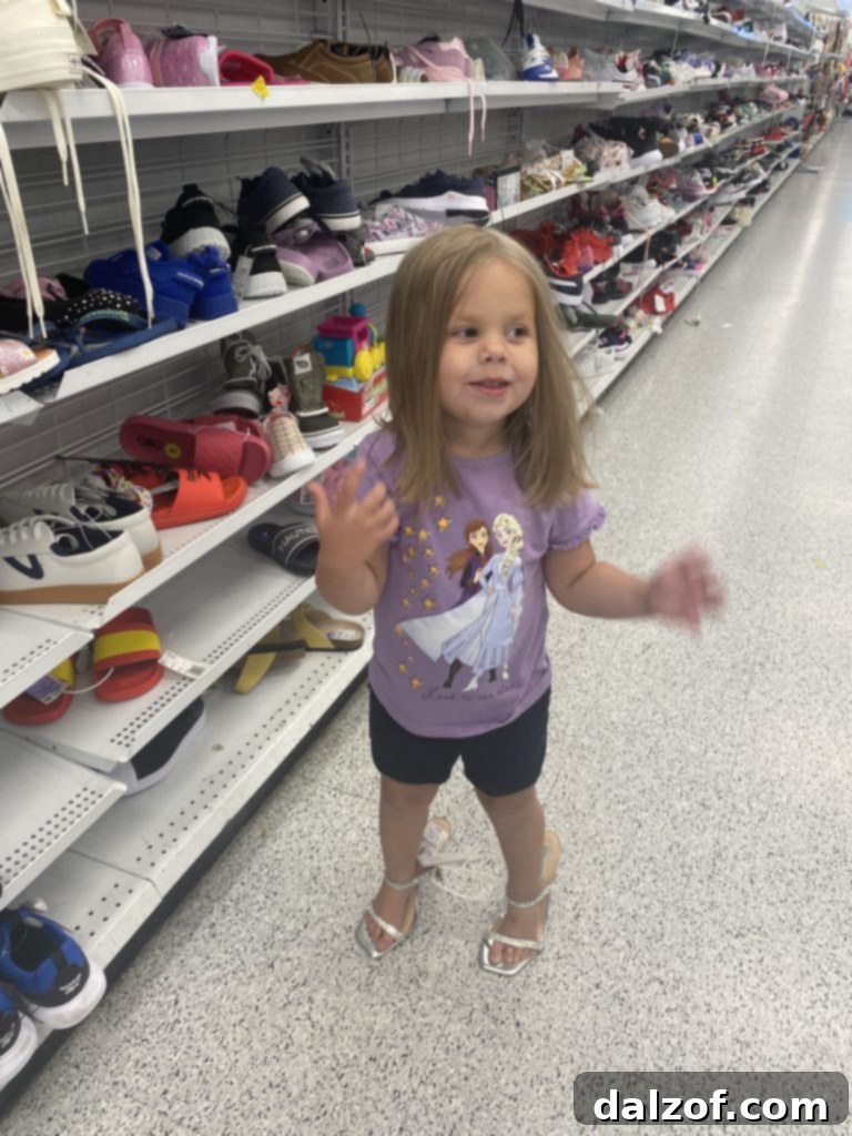 Little Miss B trying on oversized, sparkly high heels in a shoe store, much to her delight.