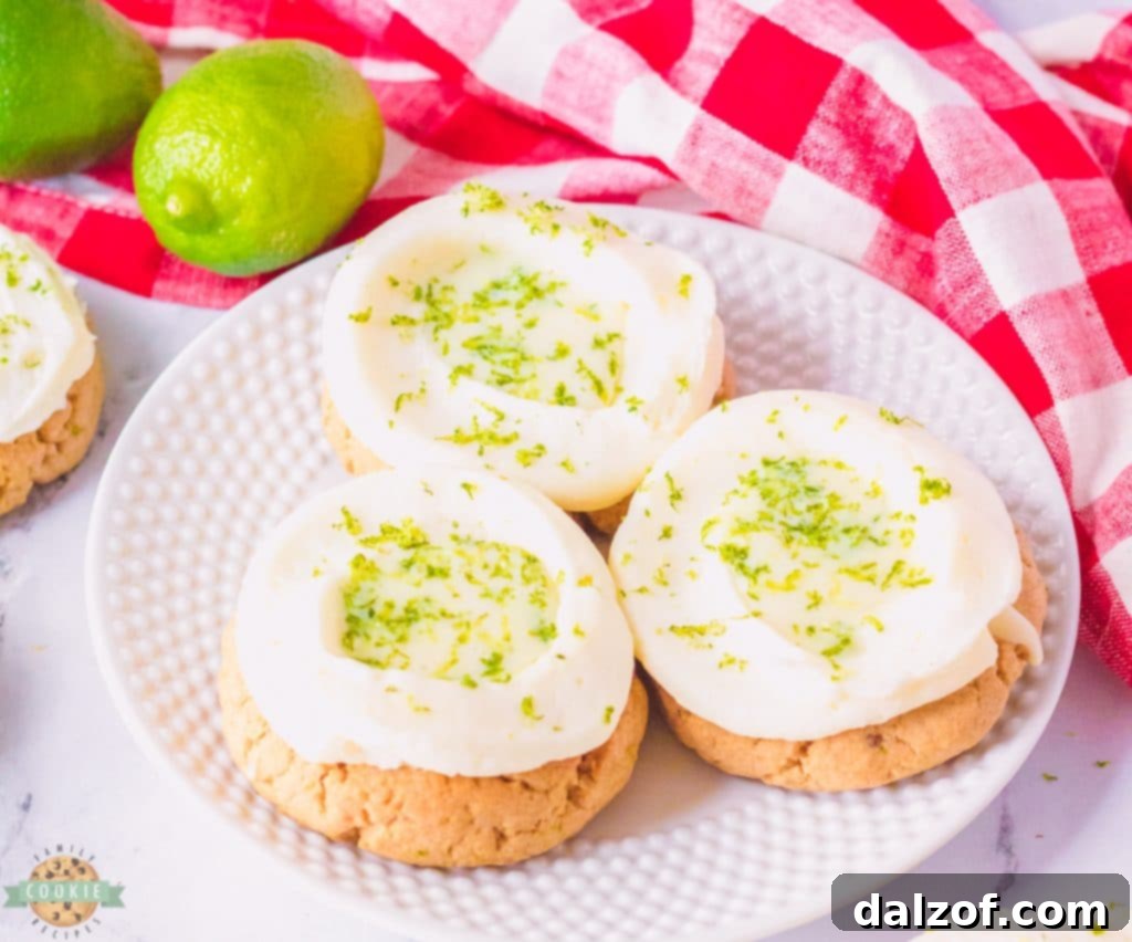 A tray of homemade lime cream pie cookies, unfrosted, showing the indented centers ready for filling.