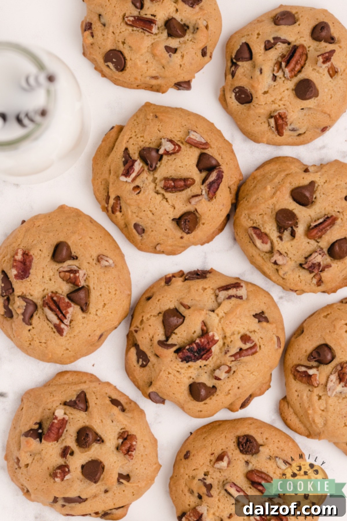 Rich Honey Maple Chocolate Chip Cookies 9 A rustic cutting board laden with freshly baked Honey Maple Chocolate Chip Cookies, garnished with extra chocolate chips and pecans, highlighting their enticing texture.