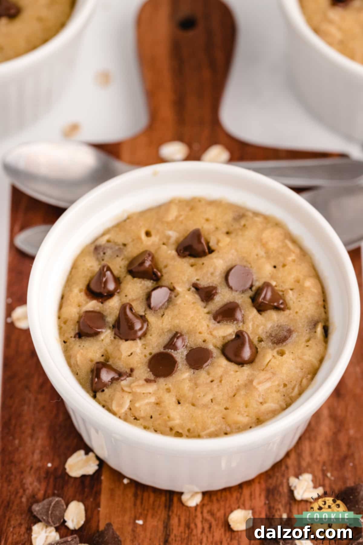 A freshly made oatmeal chocolate chip cookie, perfectly baked in a mug using a microwave.