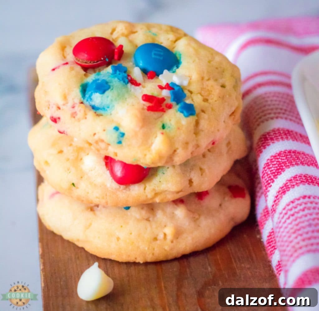 Stack of red, white, and blue M&M cookies with visible Rice Krispies, ready for a 4th of July celebration.