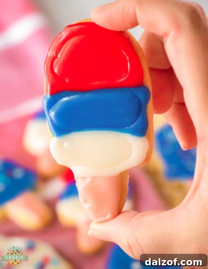 Close-up of cute ice cream cone and popsicle cookies, showcasing vibrant royal icing and sprinkles.