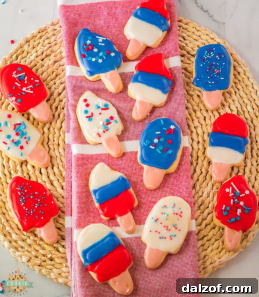 Red, white, and blue patriotic popsicle sugar cookies, perfectly decorated for a celebration.