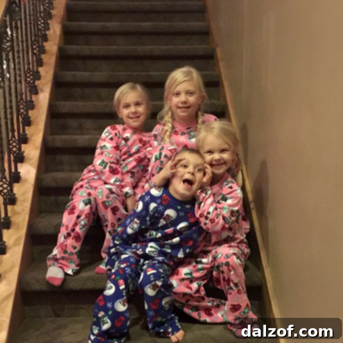 A cherished family Christmas morning tradition: kids on the stairs before opening presents, captured in a joyful moment of holiday anticipation.