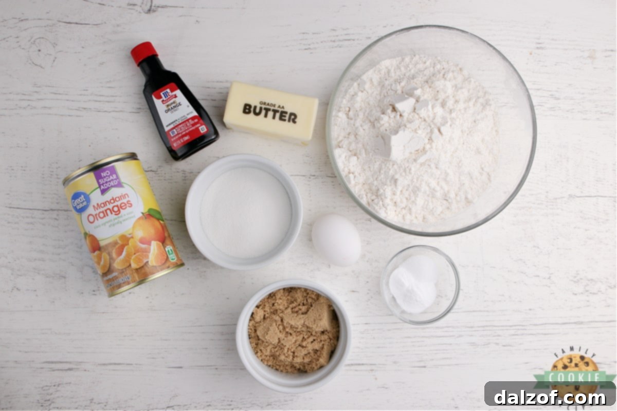 Key ingredients for making Glazed Mandarin Orange Cookies, including butter, sugars, egg, orange extract, baking soda, salt, flour, and canned mandarin oranges.