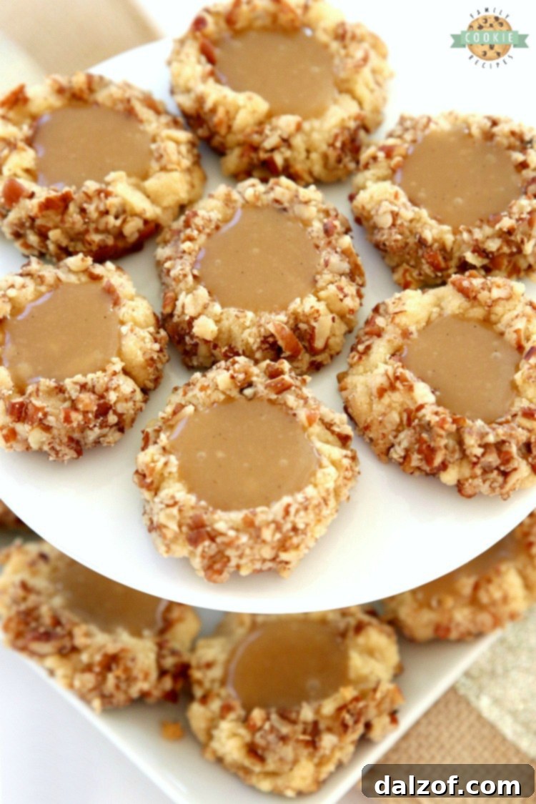 Caramel Thumbprint Cookies are a classic shortbread cookie rolled in pecans, baked & filled with warm caramel. Buttery Christmas cookies that everyone loves seeing at holiday cookie exchanges!