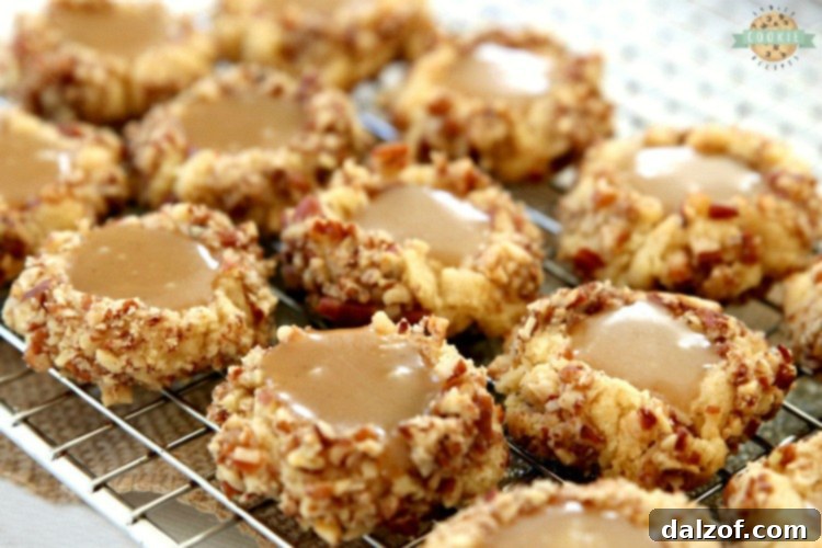 Caramel Thumbprint Cookies are a classic shortbread cookie rolled in pecans, baked & filled with warm caramel. Buttery Christmas cookies that everyone loves seeing at holiday cookie exchanges!