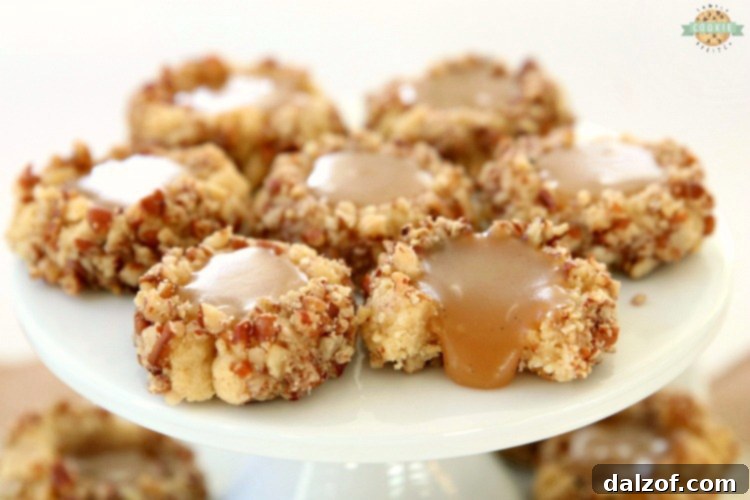 Caramel Thumbprint Cookies are a classic shortbread cookie rolled in pecans, baked & filled with warm caramel. Buttery Christmas cookies that everyone loves seeing at holiday cookie exchanges!