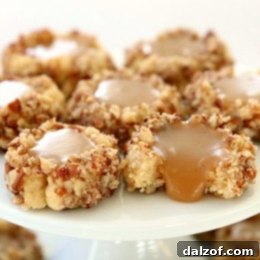 Caramel Thumbprint Cookies are a classic shortbread cookie rolled in pecans, baked & filled with warm caramel. Buttery Christmas cookies that everyone loves seeing at holiday cookie exchanges!