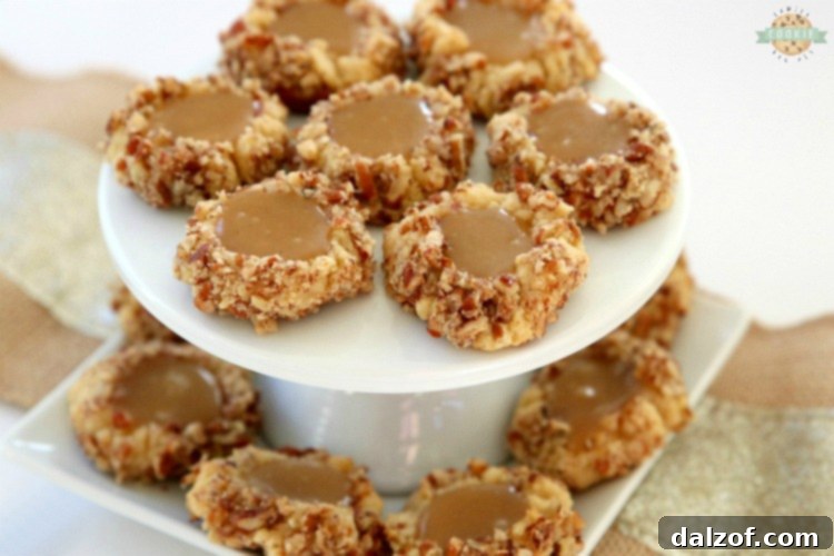 Caramel Thumbprint Cookies are a classic shortbread cookie rolled in pecans, baked & filled with warm caramel. Buttery Christmas cookies that everyone loves seeing at holiday cookie exchanges!