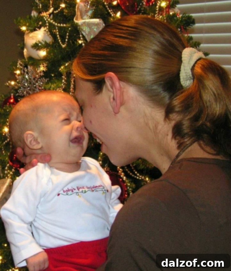 A heartwarming image of a parent holding a baby during their first Christmas, capturing a personal family moment. Reflects the joy and chaos of holiday traditions.