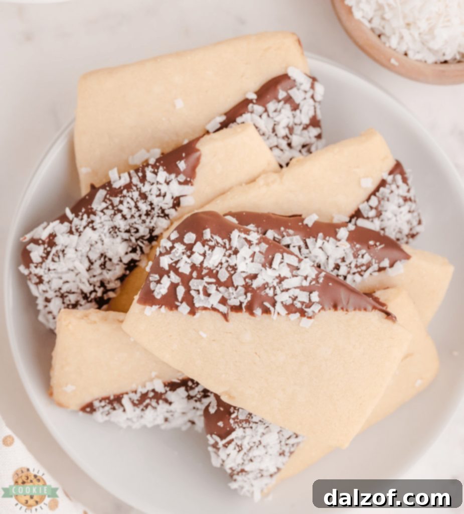 Buttery Coconut Shortbread Cookies, dipped in chocolate and dusted with coconut flakes.
