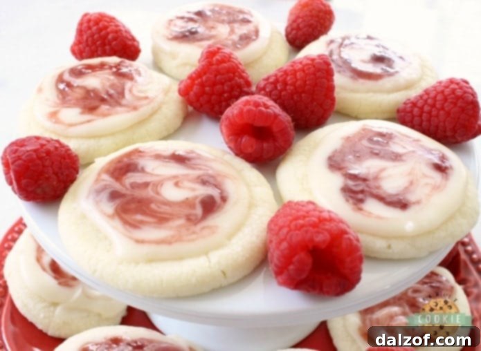 Raspberry Meltaway Cookies just melt in your mouth! Soft dough made with cornstarch and powdered sugar compliments these raspberry cookies beautifully. Perfect topped with a simple almond glaze swirled with raspberry jam.