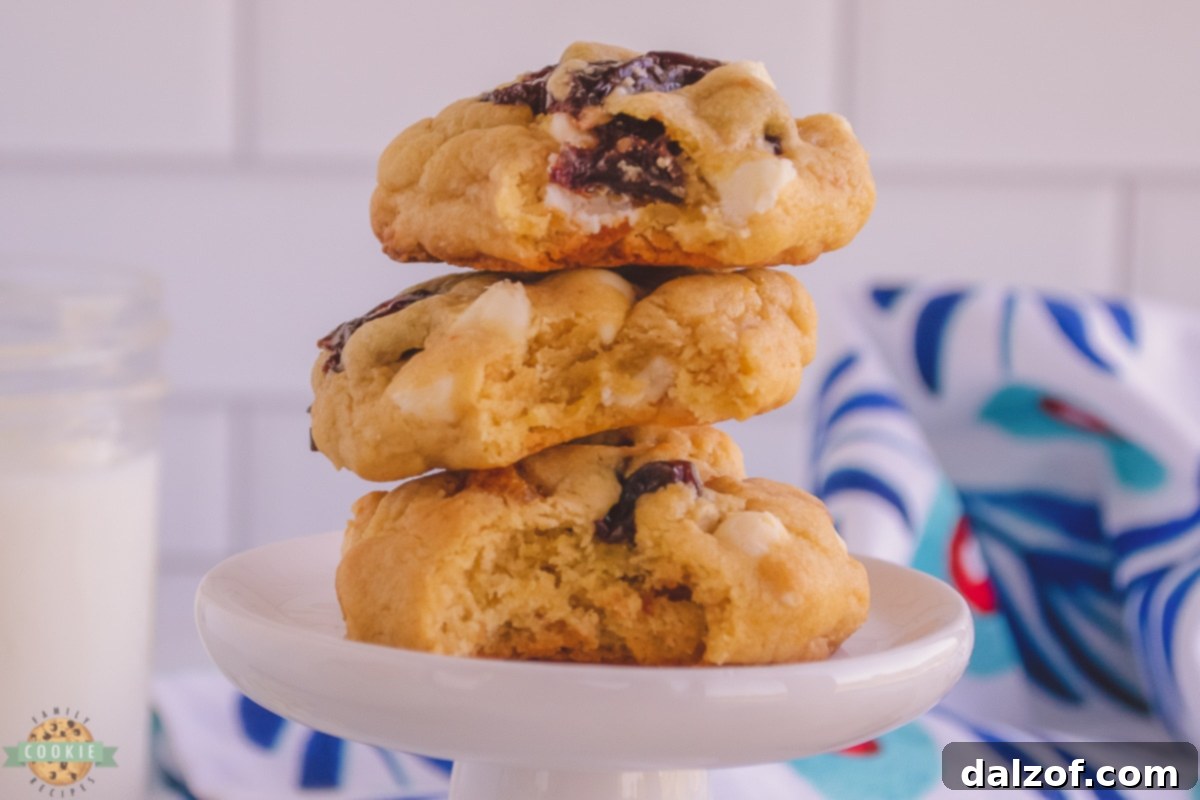 A stack of perfectly chewy white chocolate cherry cookies, showcasing their inviting texture and colorful inclusions.