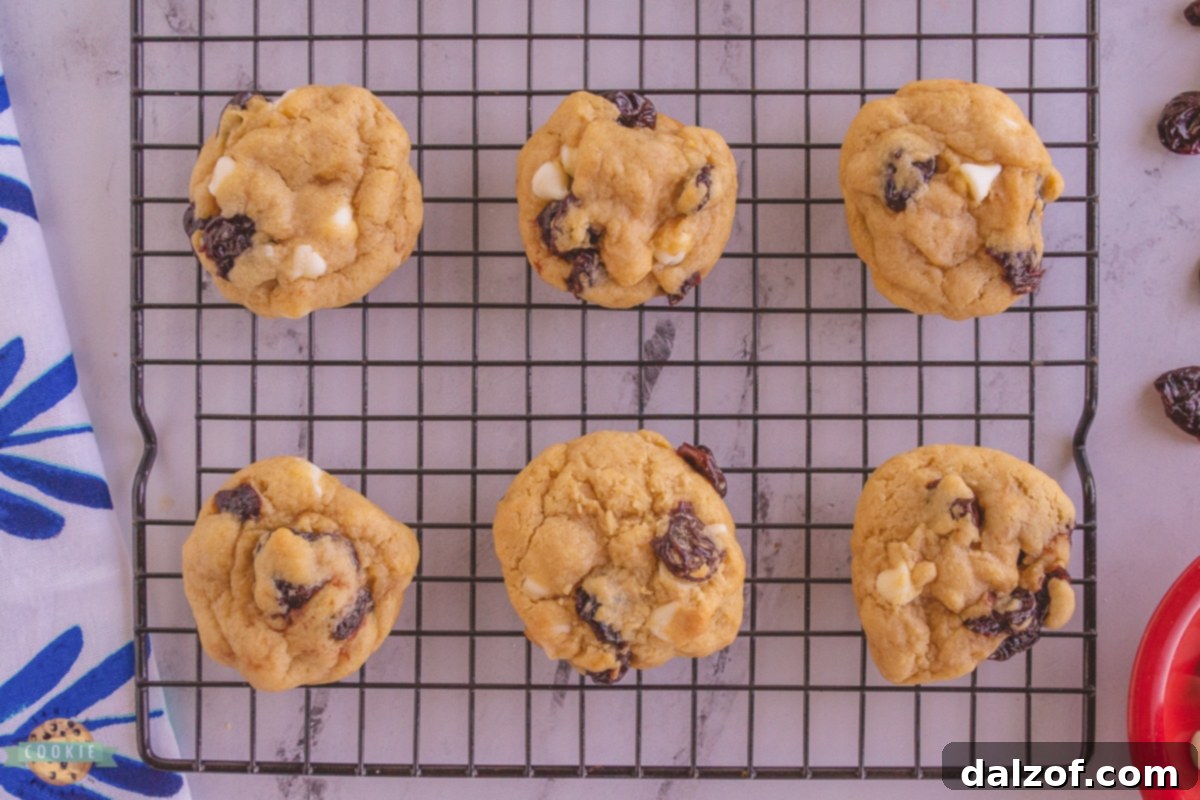 Warm white chocolate cherry cookies cooling on a wire rack after baking.