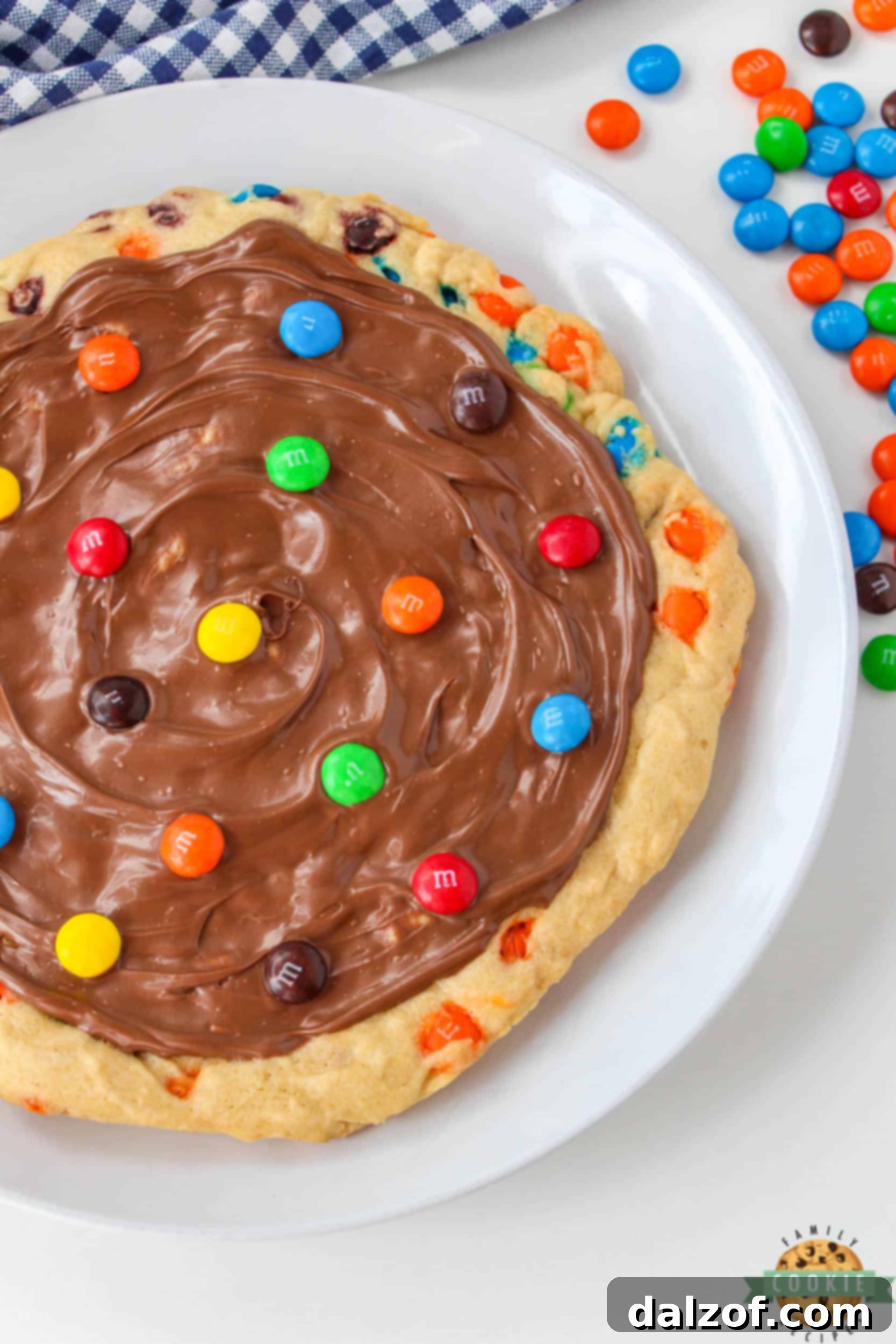 Dessert pizza frosted with milk chocolate and topped with M&Ms