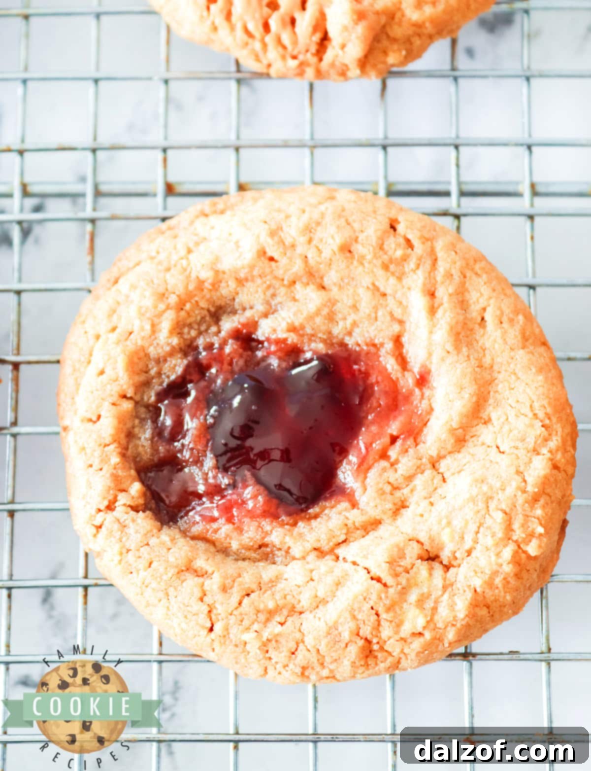 Close-up of freshly baked Peanut Butter and Jelly Cookies, showcasing the golden-brown edges and vibrant jelly centers.