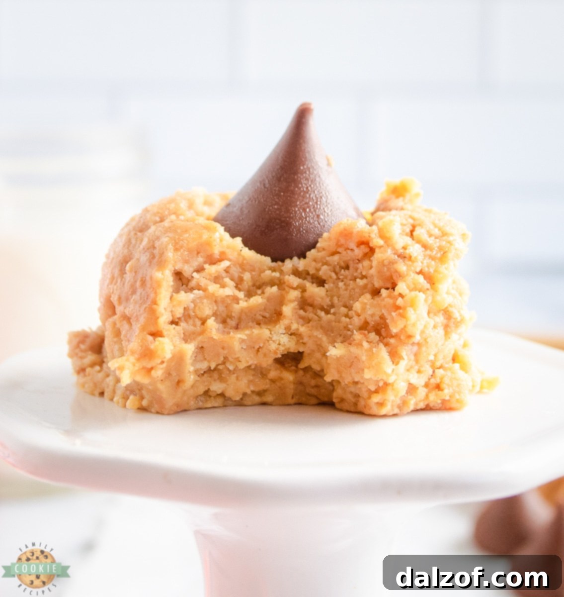 A no-bake peanut butter cookie with a bite taken out, showing the soft, rich texture and the melted chocolate kiss.