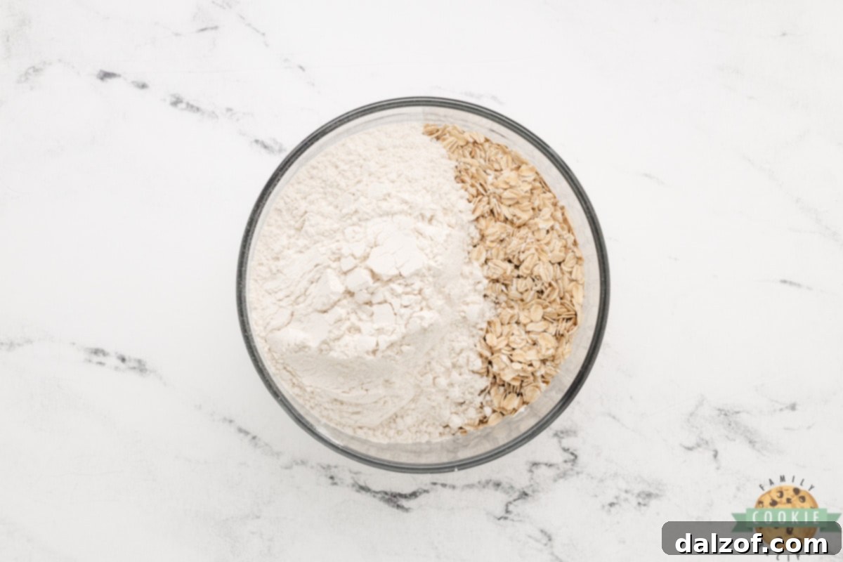 Dry ingredients for oatmeal chocolate chip cookies: oats, flour, baking soda, baking powder, and salt.