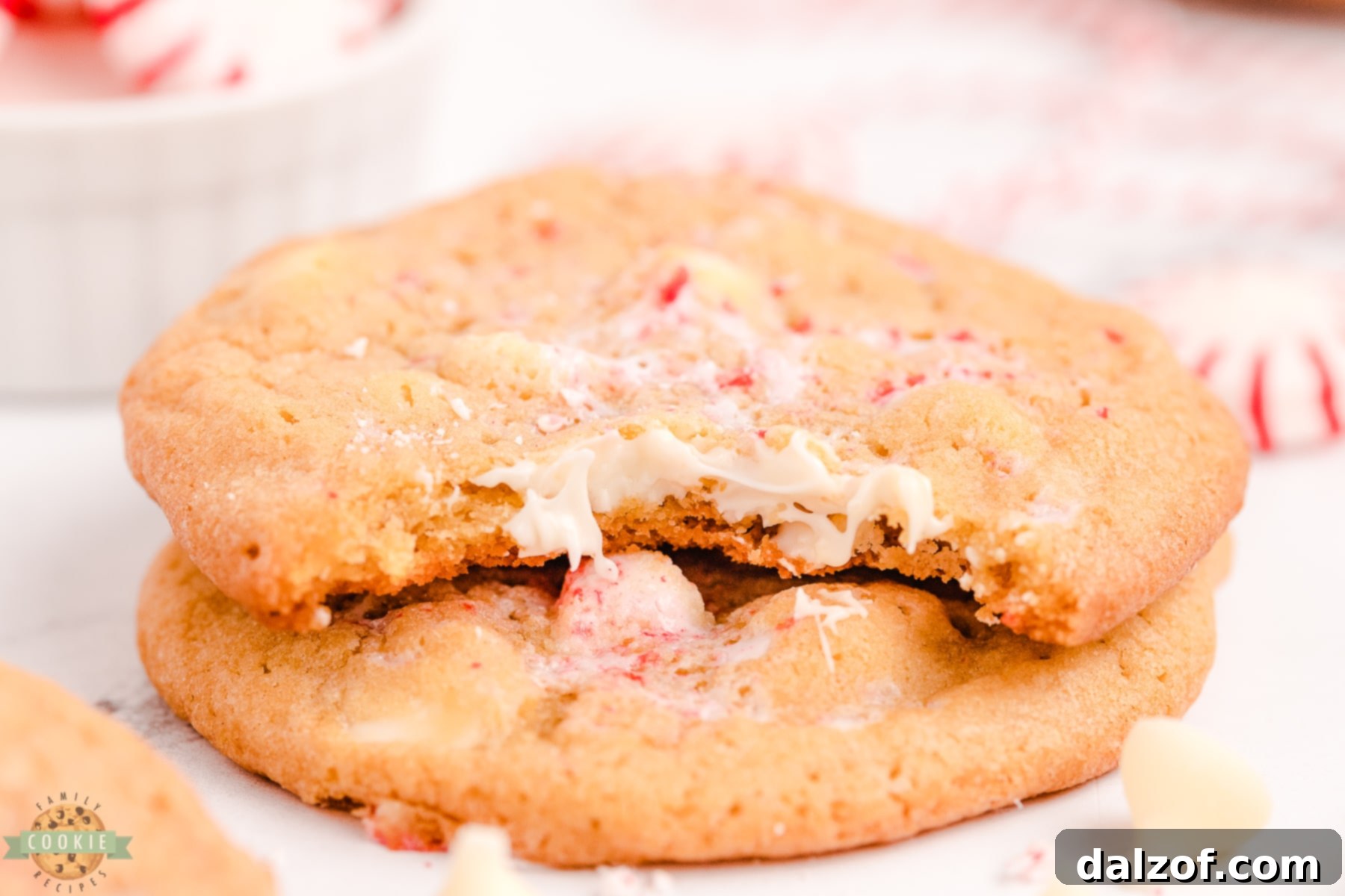 A peppermint white chocolate chip cookie with a bite taken out, showing the soft interior and visible peppermint pieces.