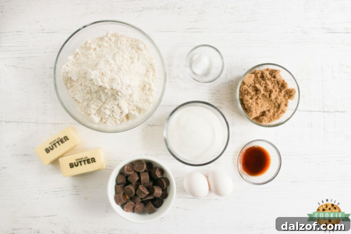 A flat lay photograph showcasing all the fresh ingredients required for Stuffed Rolo Cookies: flour, baking soda, brown sugar, granulated sugar, softened butter sticks, vanilla extract, eggs, and a pile of unwrapped Rolo candies.