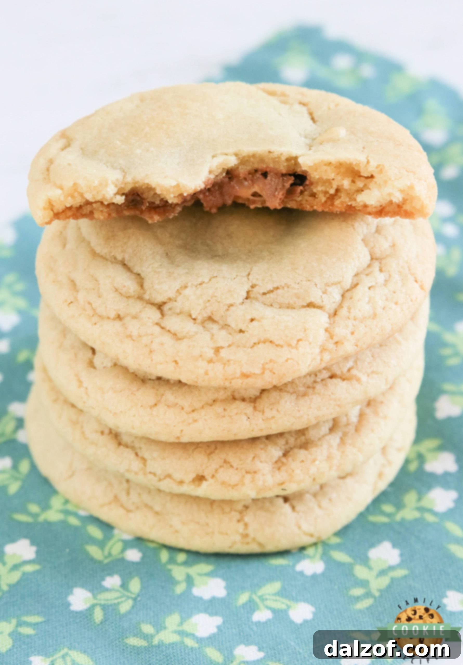 A close-up shot of freshly baked cookies, highlighting the melted chocolate and caramel centers from the Rolo candies.