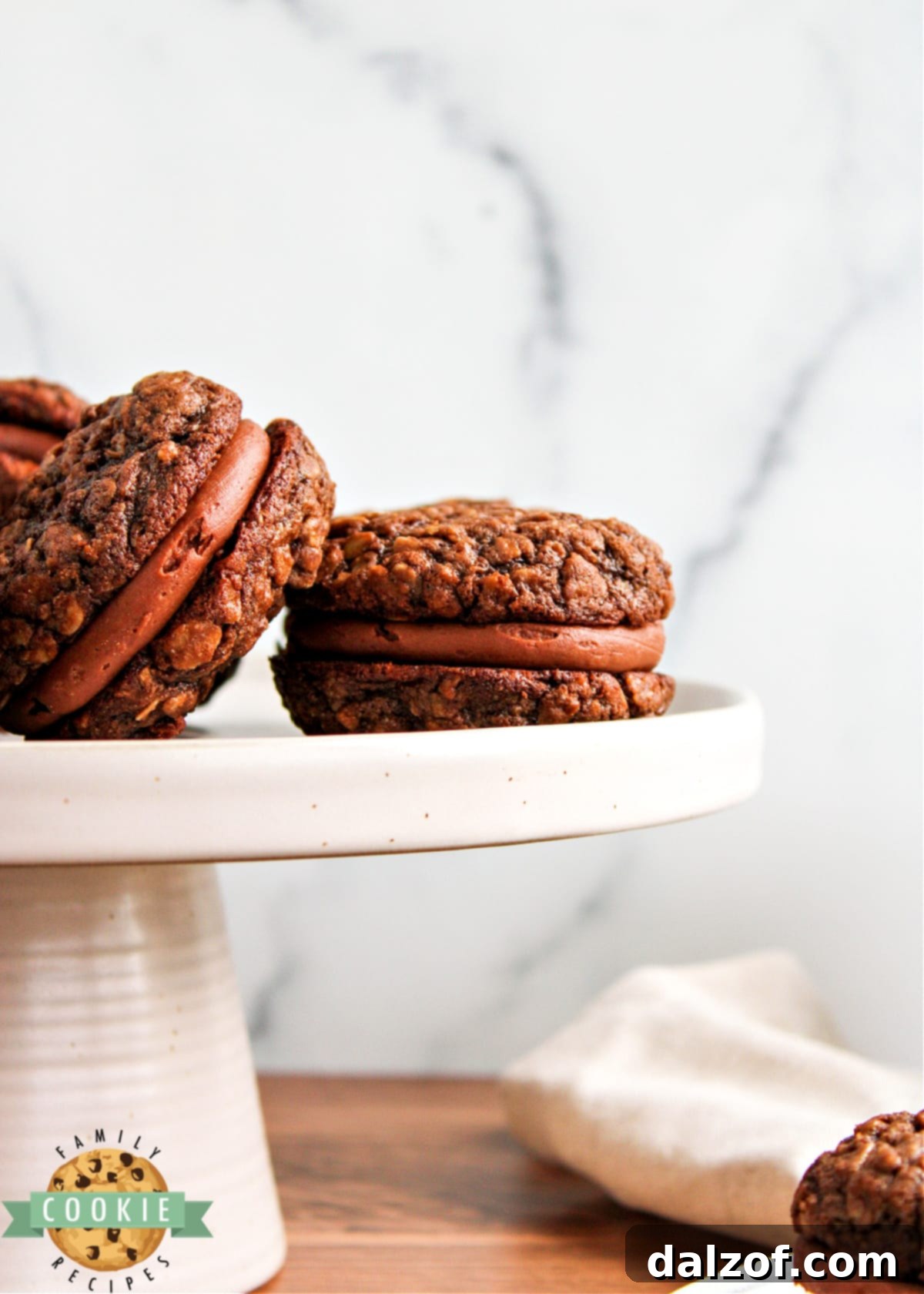 Decadent Chocolate Oatmeal Cream Pies 13 A stack of chocolate sandwich cookies filled with rich chocolate buttercream frosting.