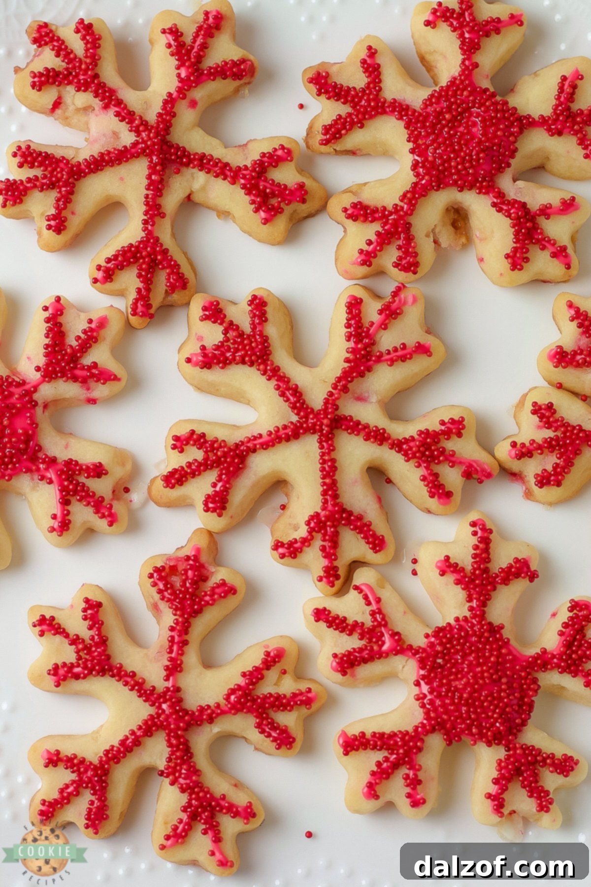 A festive array of red snowflake peppermint cut out cookies on a white plate