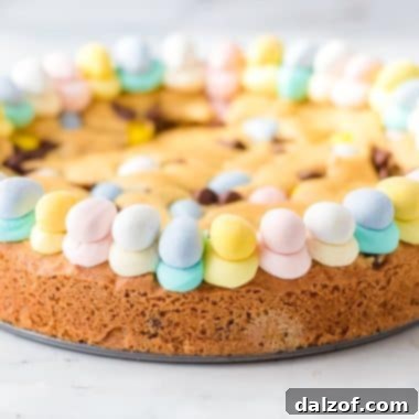 Delightful pastel Easter cookie cake, richly decorated with colorful buttercream frosting and mini chocolate eggs, a perfect centerpiece for your holiday table.