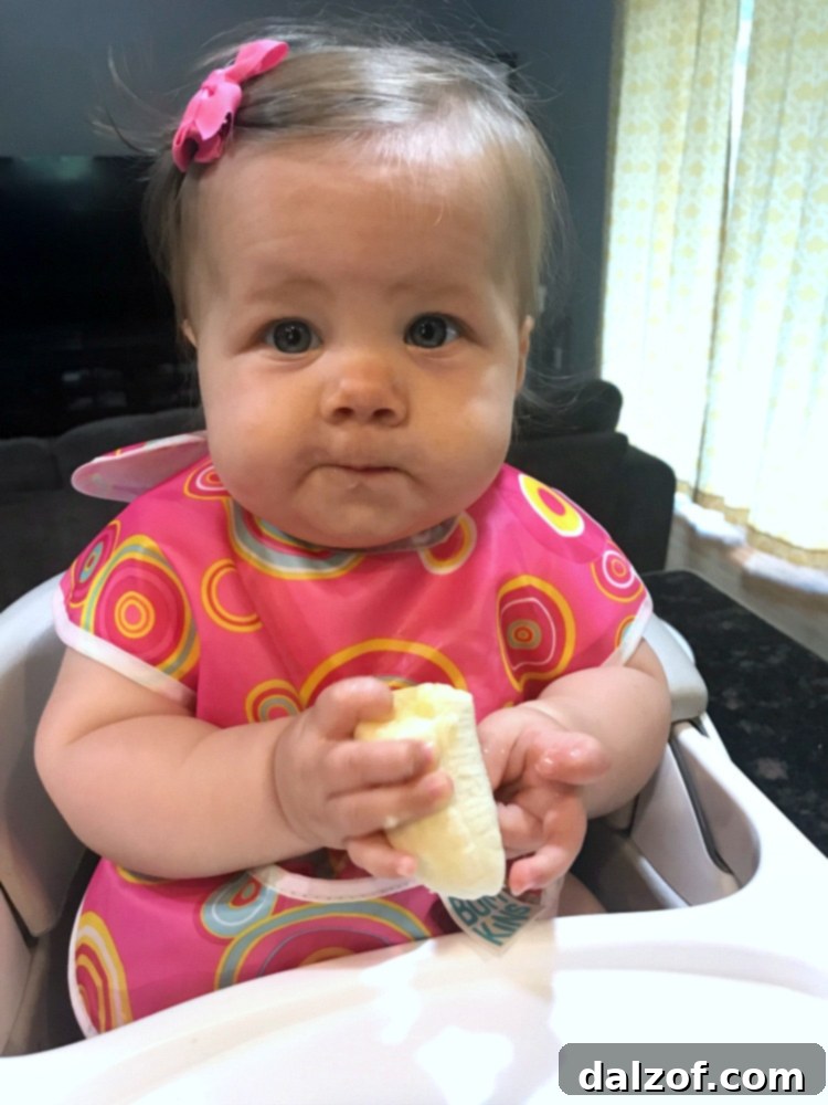 A happy baby enjoying a banana, representing the joy of family and food shared.