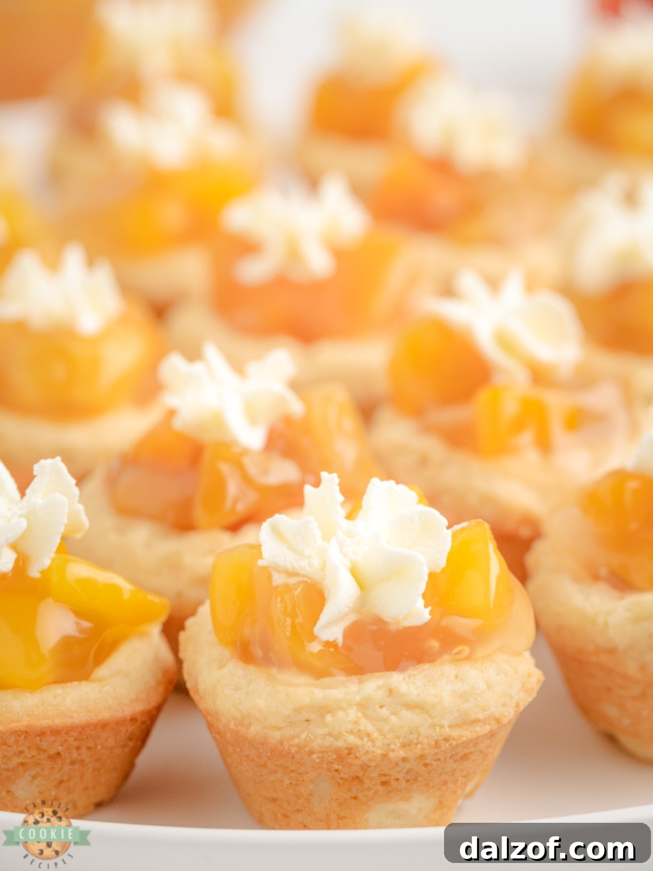 Perfectly arranged peaches and cream cookies on a pristine white plate, showcasing their inviting golden hue and creamy topping.