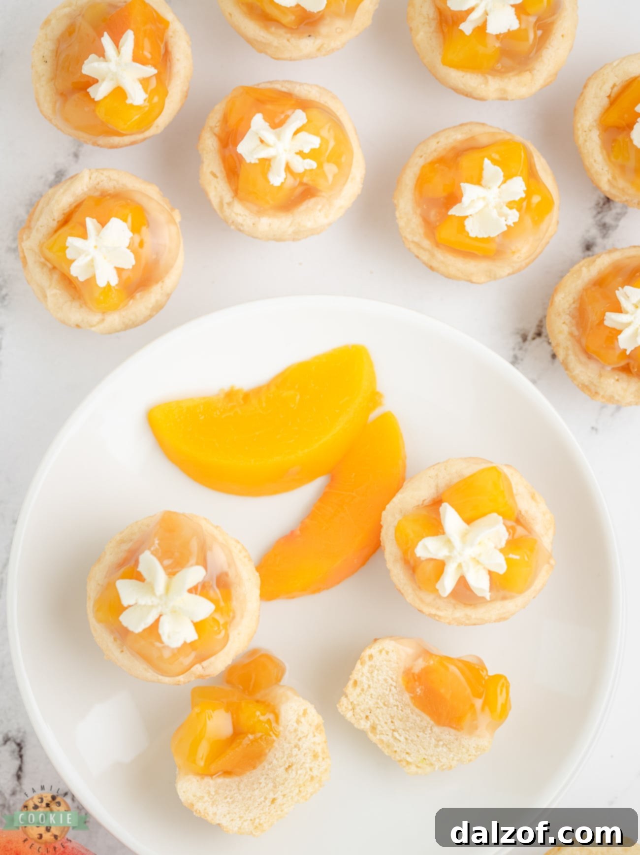 Freshly baked mini peach pie cookies with a golden crust, cooling in a muffin tin.