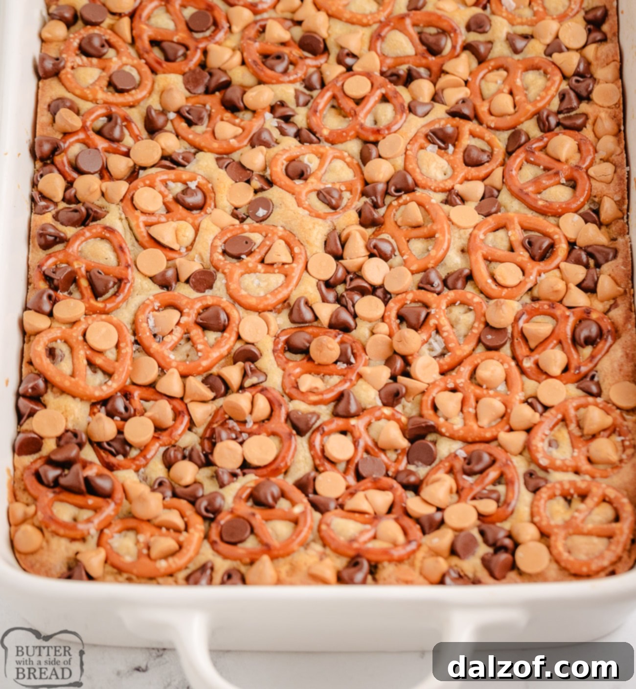 A full tray of freshly baked butterscotch pretzel cookie bars, ready to be cut and served.