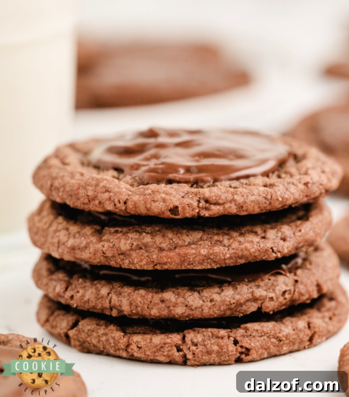 Stack of brownie mix cookies that are frosted with a melted Hershey bar.