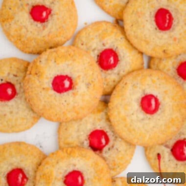 Close-up of a Cherry Crunch Cookie, showcasing the crispy cornflake exterior, shredded coconut, and a vibrant cherry center.