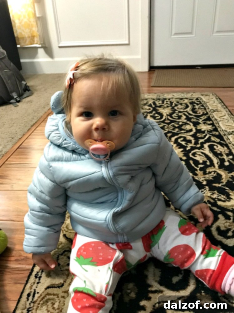 A baby, Miss B, in a warm winter coat outdoors, symbolizing cozy family moments.
