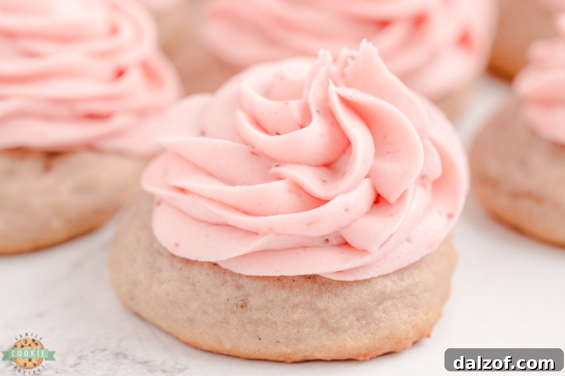 Sweet Frosted Strawberry Cookies 3 A close-up of a strawberry sugar cookie topped with perfectly swirled strawberry buttercream frosting, highlighting the texture and color.