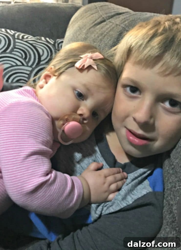 A heartwarming photograph of two siblings, Camden and Brooklyn, sharing a sweet moment.