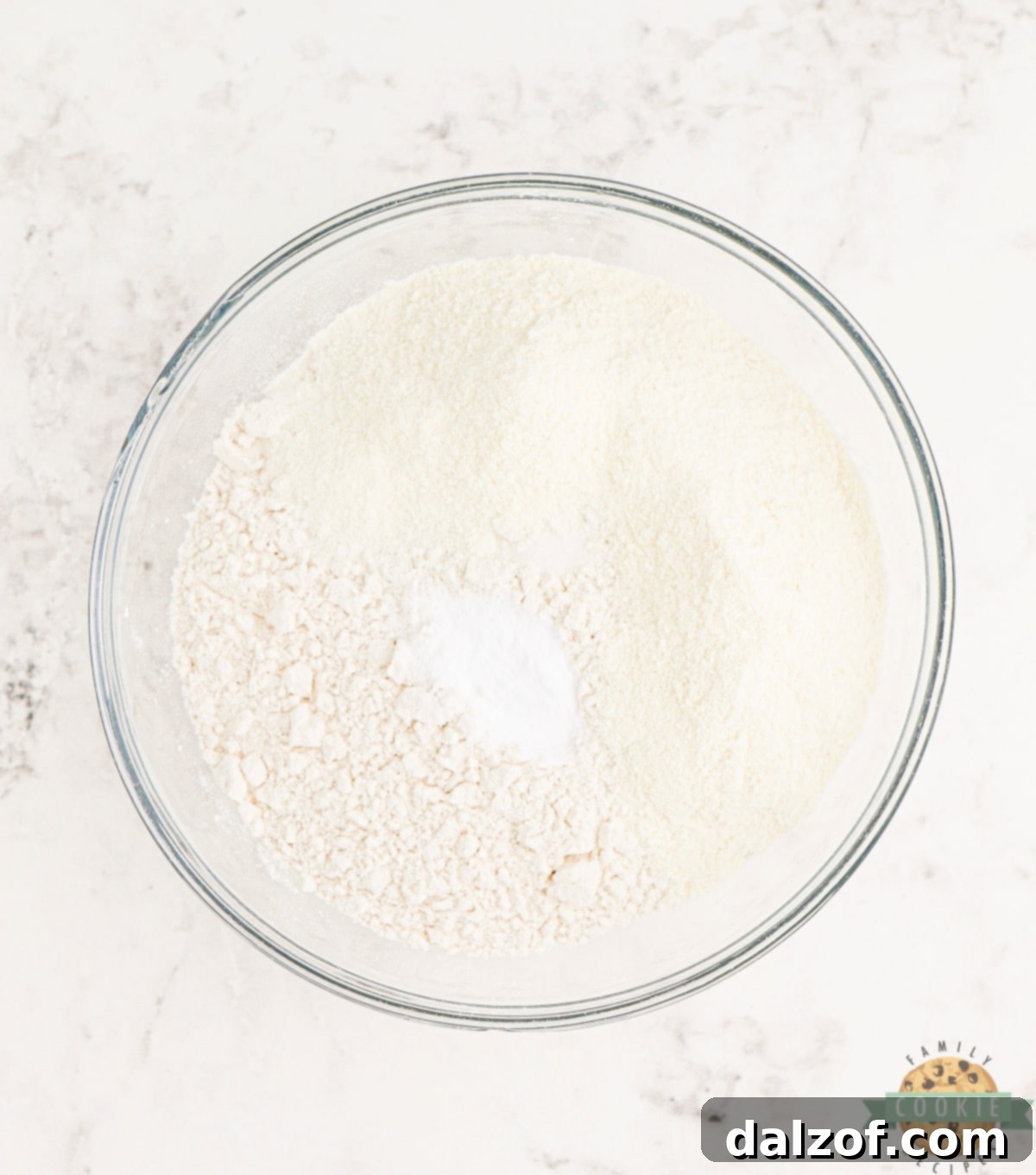 Dry ingredients for Funfetti Cookies, including flour, vanilla pudding mix, baking soda, and salt, in a mixing bowl.