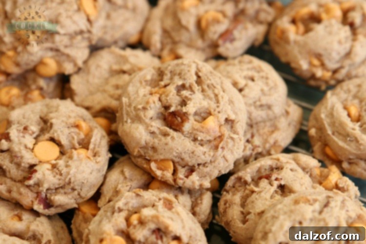 A stack of Caramel Spice Cake Mix Cookies with a bite taken out, showing the soft interior with caramel and pecans.