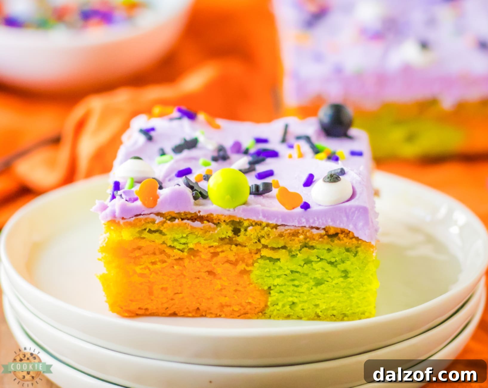 Marbled orange and green Halloween sugar cookie bars with purple frosting on a plate, ready to be enjoyed.