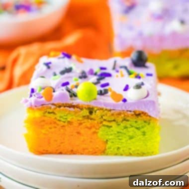Marbled orange and green Halloween sugar cookie bars with purple frosting on a plate, a festive treat for Halloween.