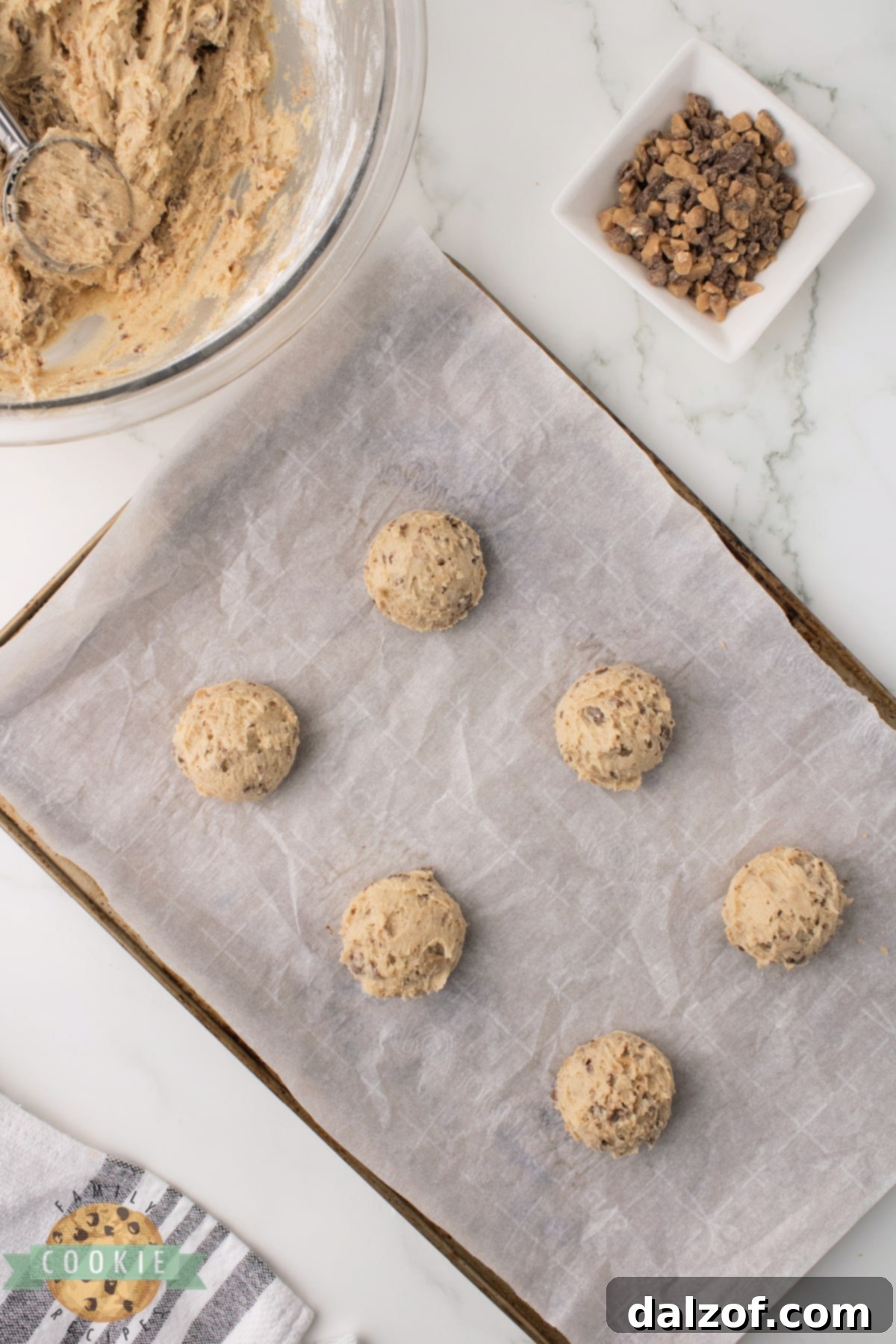 Scooping out Heath Bar Cookie dough onto a baking sheet