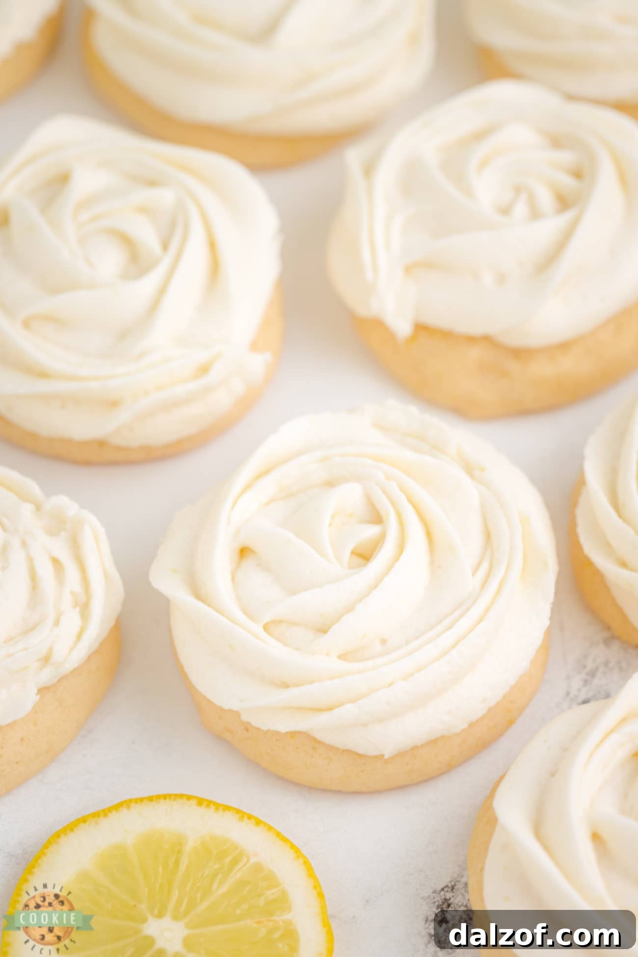 Frosted lemon sugar cookies with piped rosettes arranged beautifully on a serving dish.