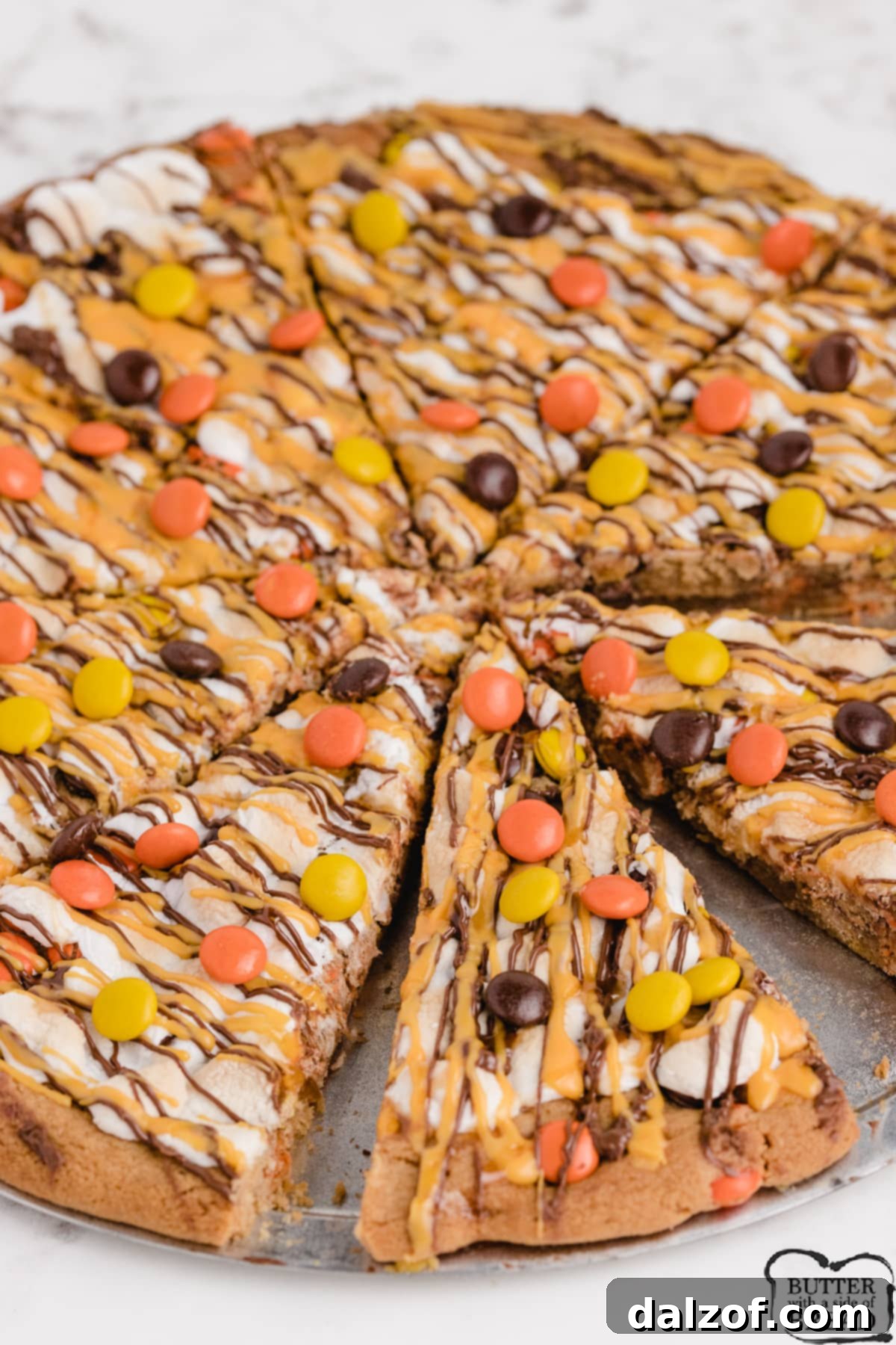 Halloween Peanut Butter Cookie Pizza with Reese's Pieces and colorful drizzles