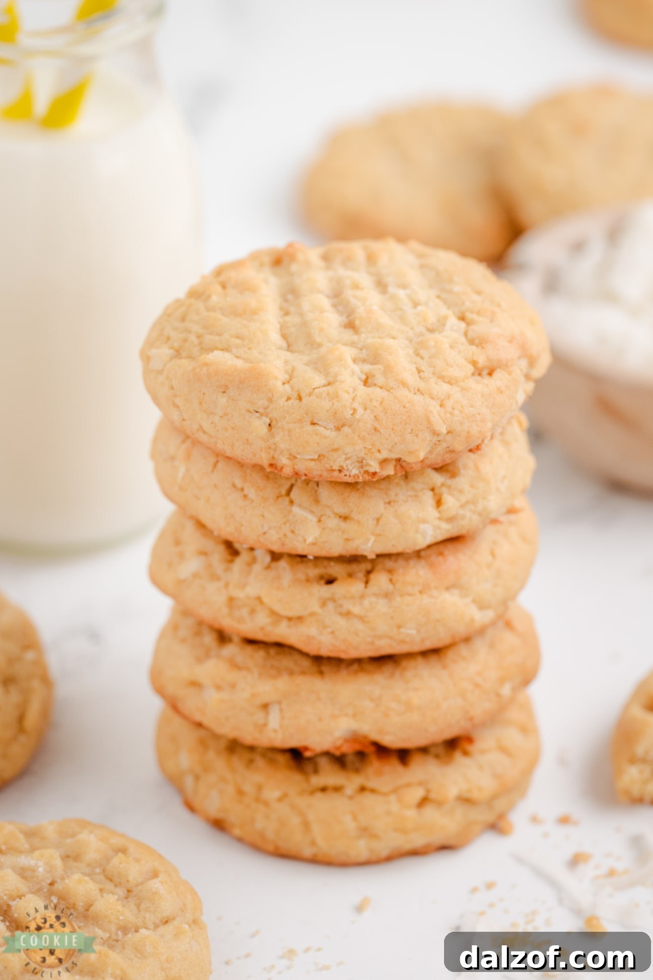 A beautiful stack of five golden chewy coconut cookies, showcasing their perfect texture.