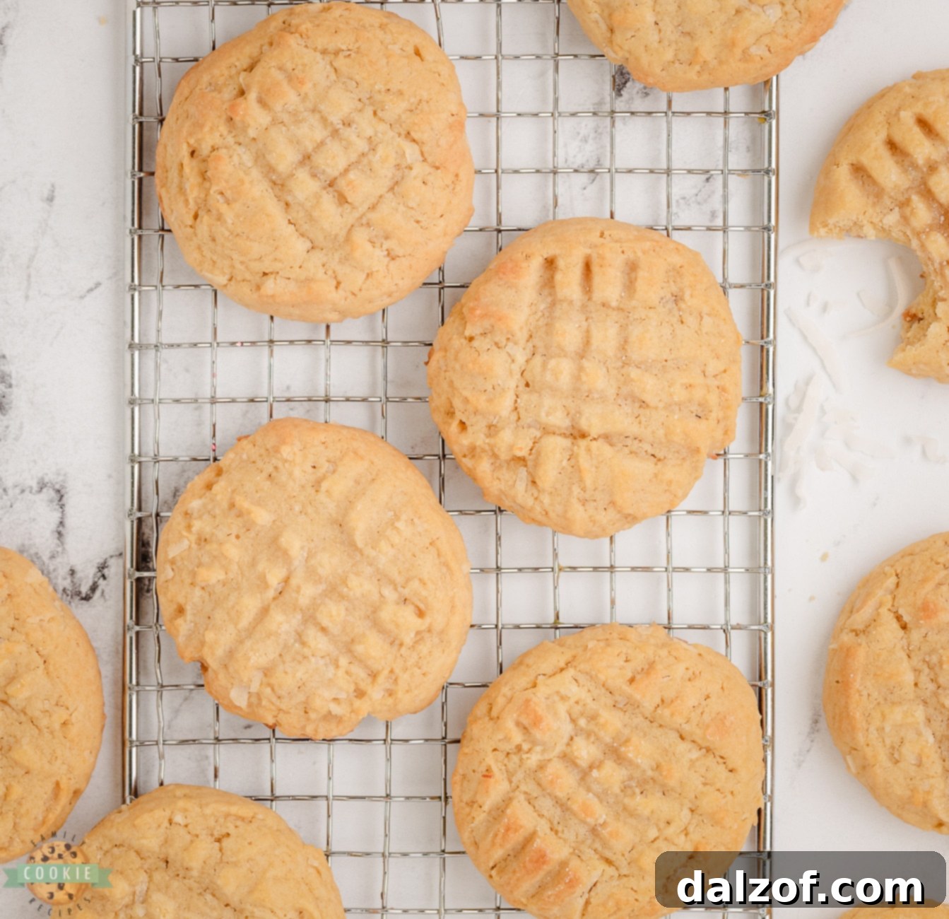 Freshly baked coconut cookies cooling on a wire rack after coming out of the oven.