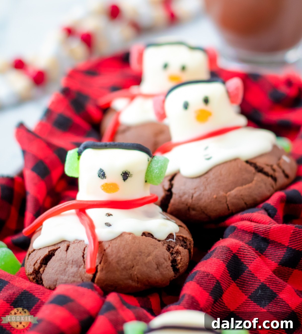 Whimsical Peppermint Snowman Cookies featuring a chocolate cookie base and a melted marshmallow snowman decoration.